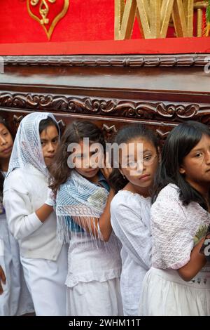 Antigua, Guatemala.  Semana Santa (Holy Week).  Young Girls Carrying an Anda (Float) of the Virgin Mary in a Religious Procession. Stock Photo