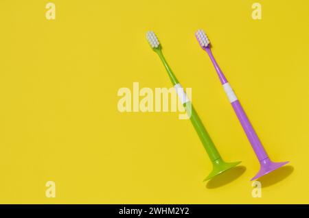 Two plastic toothbrushes on a yellow background, oral hygiene Stock Photo