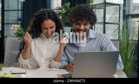 Multiracial business partners multiethnic colleagues Indian businessman and Arabian businesswoman working together paperwork in office happy team Stock Photo