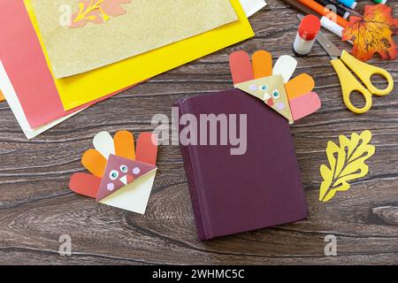 Thanksgiving craft bookmark turkey paper on a wooden table. Childrens art project, handmade, autumn crafts for kids. Stock Photo