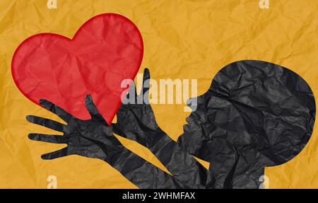 The silhouette of a person cut out of crumpled paper holds a red heart in their hands on a yellow background. The concept of lov Stock Photo