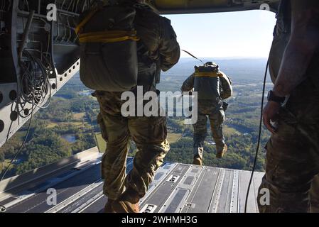 Members of the U.S. Army 20th Special Forces Group execute HALO and Static Line jumps out of a U.S. Army CH-47 Chinook Helicopter assigned to the Bravo Company, 1-169th Aviation over an undisclosed location, Oct. 14, 2023. The jumps were part of a training exercise to keep members currency up to date. (U.S. Air National Guard photo by Staff Sgt. Nicholas Faddis) Stock Photo