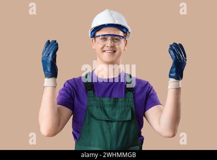 Male electrician in gloves on brown background Stock Photo