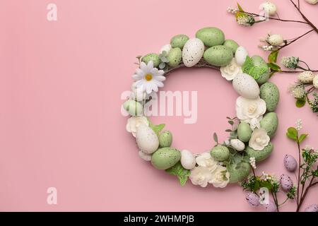 Easter wreath with flowers, eggs and butterflies on pink background Stock Photo