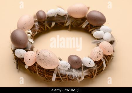 Easter wreath made of eggs and feathers on beige background Stock Photo