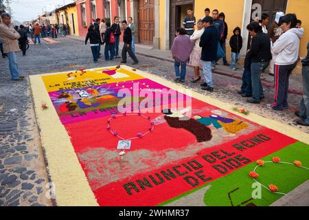 Antigua, Guatemala.  An alfombra (carpet) of flowers, pine needles, and other traditional materials decorates the street in advance of the passage of Stock Photo