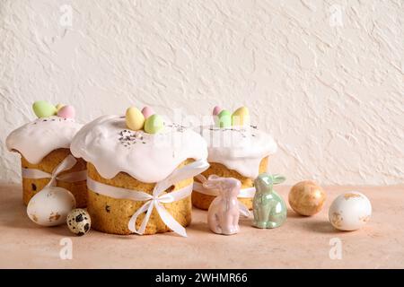 Composition with delicious Easter cakes, porcelain bunnies and painted eggs on color background Stock Photo