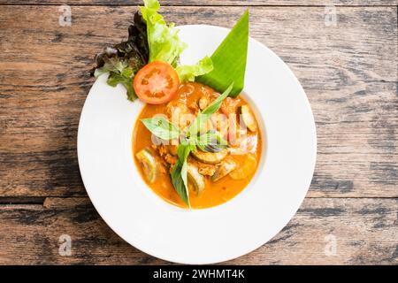 Red curry with chicken on wooden background. Stock Photo