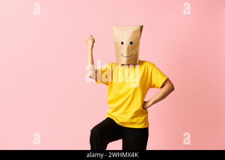 Woman with happy smile on the paper bag on head celebrating success with winner gesture Stock Photo