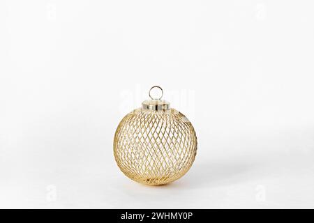 Golden metal ball close-up on white background. Christmas sustainable bauble. Christmas or New Year concept Stock Photo