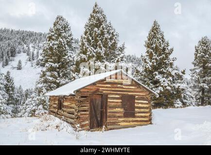 old log cabin in winter in the little blackfoot river valley near elliston, montana Stock Photo