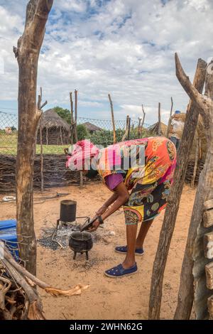 old African woman cooking in the outdoor kitchen in an African village Stock Photo