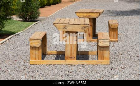 wooden table and chairs in the garden standing on a gravel alley Stock Photo