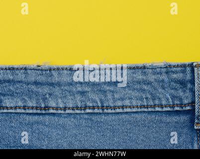 Blue jeans on a yellow background, copy space Stock Photo