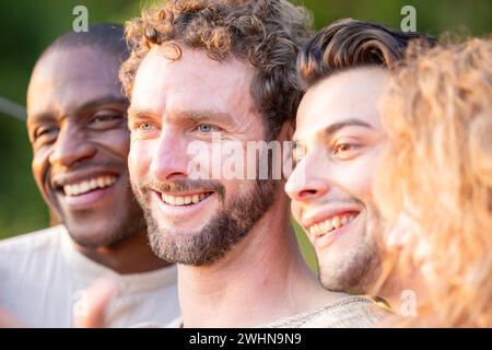 Multiracial group of friends having fun together on city street - Millenial people laughing hugging outside - Friendship concept Stock Photo