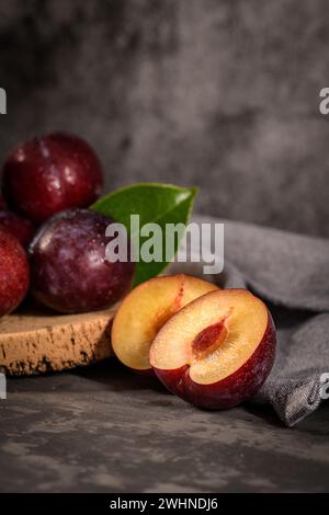 Red plums in a cork plate Stock Photo