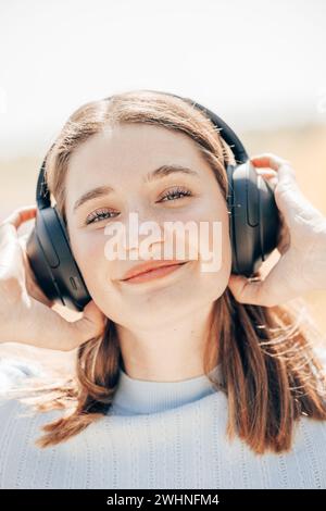 Excited young woman listening to music at a coffee shop Stock Photo - Alamy