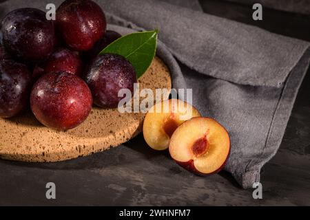 Red plums in a cork plate Stock Photo