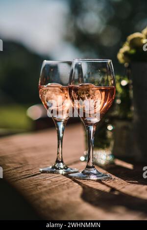 Two glasses of rose wine on wooden table Stock Photo
