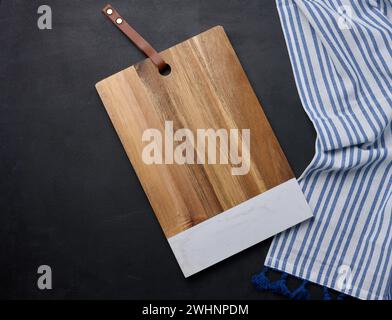 Empty rectangular wooden kitchen cutting board on black table top view Stock Photo