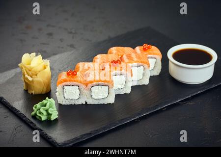 Sushi roll Philadelphia with salmon, red caviar, cream cheese on dark background. Sushi menu. Japanese food. Stock Photo
