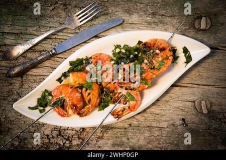 Tasty fresh shrimp skewers on plate Stock Photo