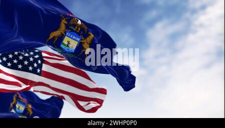 Flags of Michigan and the United States waving in the wind on a clear day Stock Photo