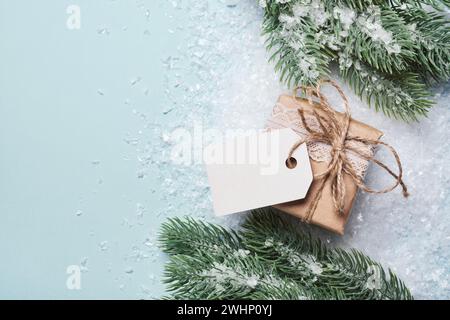 Gift box packed in paper with blank tag mockup. Eco Christmas decor Stock Photo