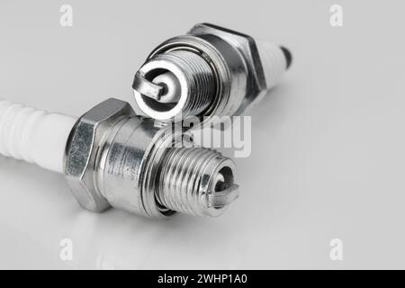 Two spark plugs for a two-stroke engine, close-up on a light background Stock Photo