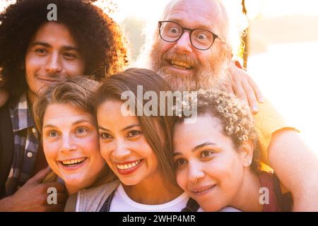 Happy young group of multiracial best friends having fun together outdoors. Millennial diverse people enjoying time together tak Stock Photo