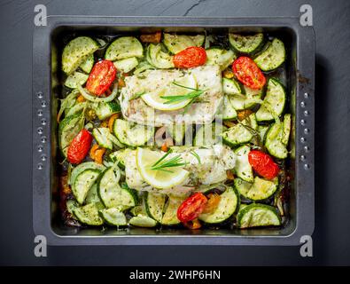 Cod fillet on paprika, onion with zucchini and cheese Stock Photo