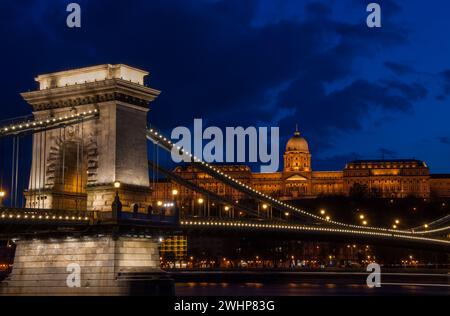 Royal Palace or the Buda Castle and the Chain Bridge after sunset in Budapest in Hungary. Stock Photo