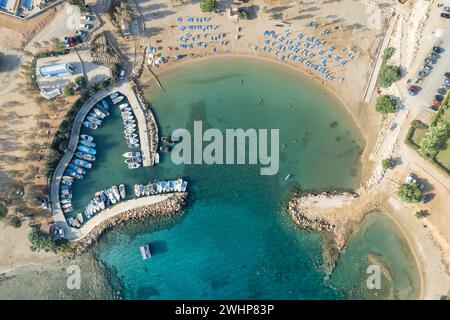 Aerial drone view of fishing harbour and sandy holiday beach for swimming. Stock Photo