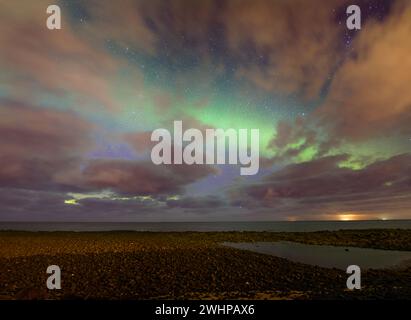 Northern lights over the sea at Skagsanden Beach, Lofoten Islands ...
