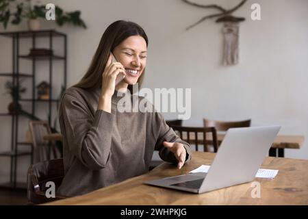 Cheerful remote professional employee woman speaking on cell Stock Photo