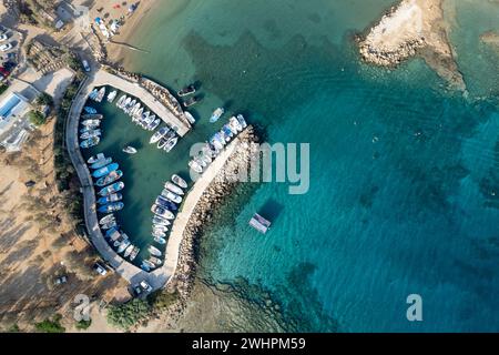 Aerial drone view of fishing harbour and sandy holiday beach for swimming. Stock Photo