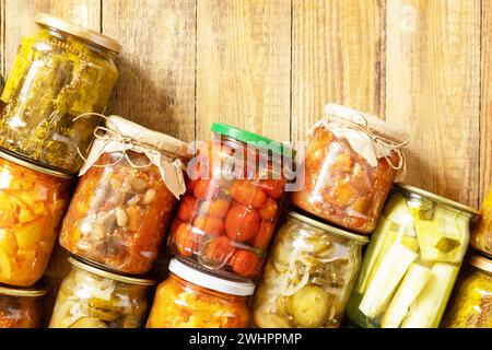 Various types of canned vegetables in glass jars on a rustic table. Healthy homemade fermented food. Home economics, autumn harv Stock Photo