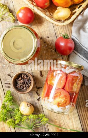 Healthy homemade fermented food. Salted pickled tomatoes and onions preserved canned in glass jar. Home economics, autumn harves Stock Photo