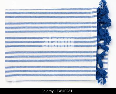 Folded white blue linen napkin with pom pom on a white isolated background, top view Stock Photo