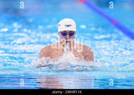 Doha, Qatar. 11th Feb, 2024. Dong Zhihao of China competes during the men's 100m breaststroke heats of swimming at the World Aquatics Championships 2024 in Doha, Qatar, Feb. 11, 2024. Credit: Du Yu/Xinhua/Alamy Live News Stock Photo