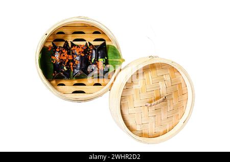 Black Dim sum dumplings in bamboo steamer. Asian cuisine. Isolated on white background. Top view Stock Photo