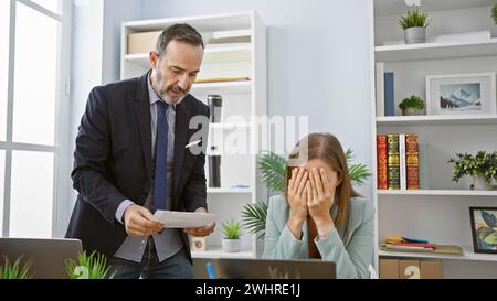 Two angry business workers engulfed in a furious argument at the office, professional partners speaking, disagreement erupting on job, nerves burning Stock Photo