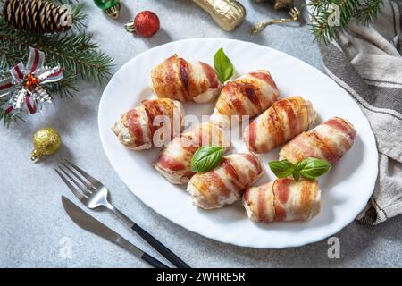 Christmas dinner, holiday menu. Baked chicken fillet with ricotta in bacon is served on a festive xmas table. Stock Photo