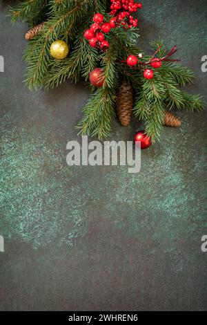 Christmas or New Year holidays composition layout. Fir tree branch and decoration on a dark stone background. Flat lay, copy spa Stock Photo
