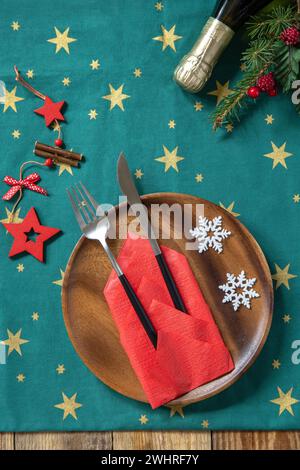 Table setting for Christmas dinner, holiday composition. Table fork and knife set with red paper napkin and fir branch on a rust Stock Photo