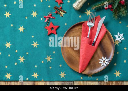 Table setting for Christmas dinner, holiday composition. Table fork and knife set with red paper napkin and fir branch on a rust Stock Photo