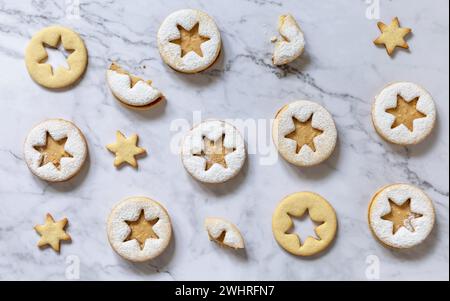 Baking background. Traditional Linzer Christmas cookies with peanut butter on a marble top. Top view flat lay background. Stock Photo