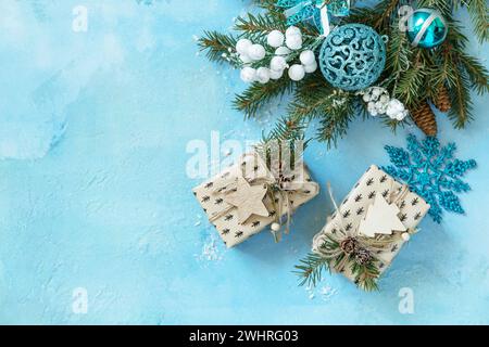 Christmas ornaments and New Year decor. Christmas balls, winter fir tree with present boxs and christmas decor on a blue stone b Stock Photo