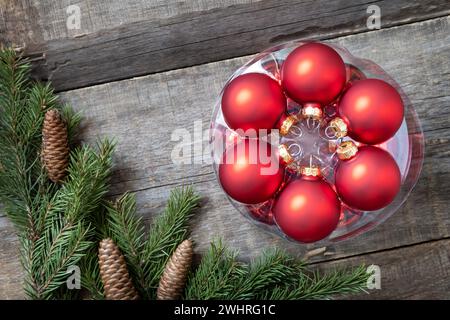Vintage Christmas postcard design. Red Christmas baubles decorations on a wooden background with copy space. Stock Photo