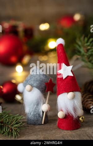 Vintage Christmas postcard design. Christmas gnomes with fir tree, christmas lights and red christmas baubles decorations. Stock Photo